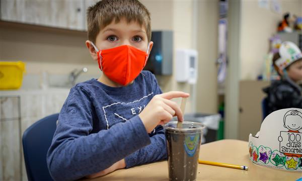 Boy smiles with cup